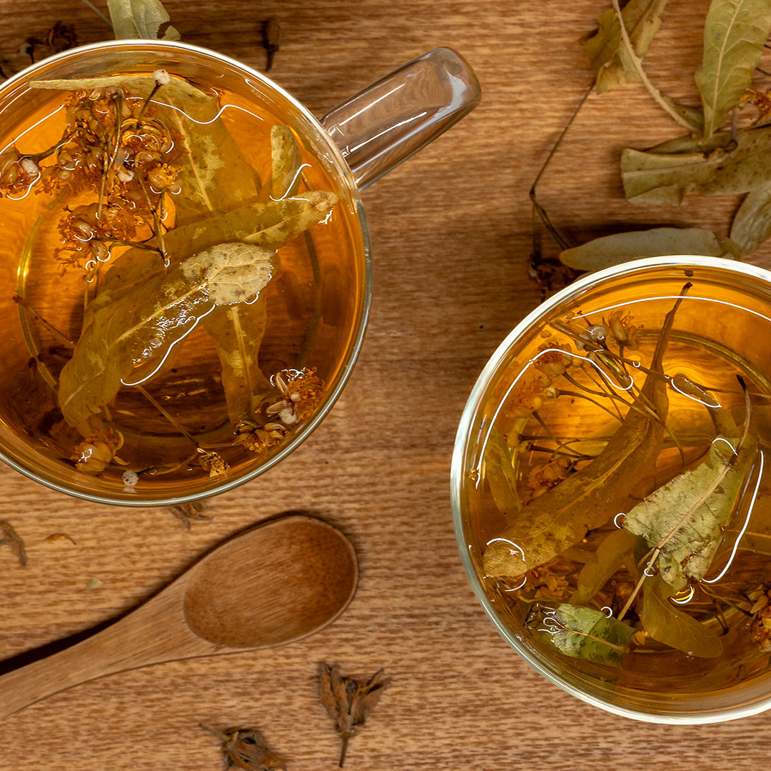 Gros plan des feuilles de tilleul qui infusent dans une tasse.